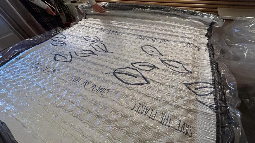 Colchão desenrolado sobre cama, ainda embrulhado em vácuo